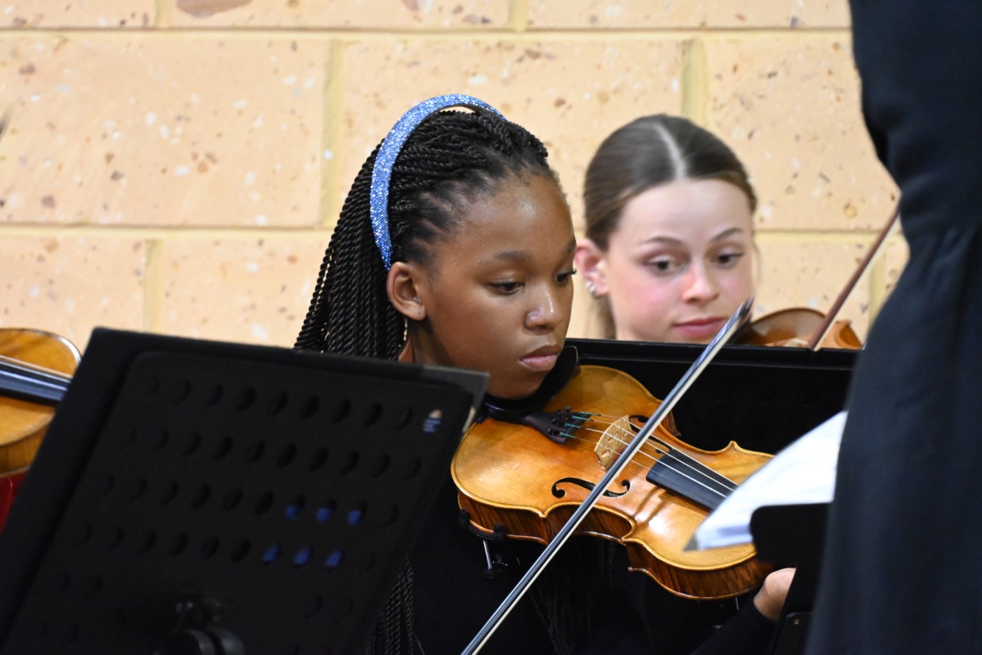 Young violinists playing together during a performance.
